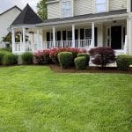 Mowing a green lawn with garden beds